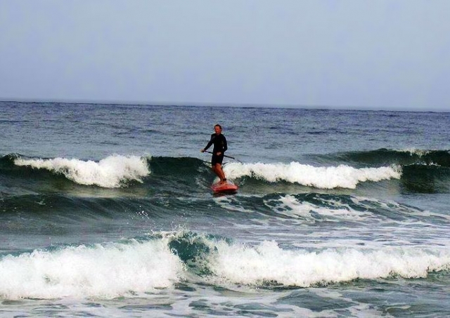  男子在海上划桨冲浪 